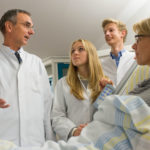 Die Studenten der Kassel School of Medicine profitieren vom praxisnahen Studium: Prof. Dr. Adrian Gillissen, Direktor der Klinik für Lungen- und Bronchialmedizin (links), demonstriert Studieninteressenten das sogenannte Bedside-Teaching. Der patientennahe Unterricht ist Teil des Lehrplans. Das Gespräch mit Patienten und das richtige Verhalten ihnen gegenüber soll den angehenden Ärzten schon früh zur Selbstverständlichkeit werden. Foto: Gesundheit Nordhessen