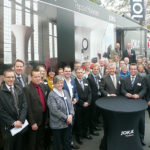 Bevor die Verbandsjuristen über aktuelle Themen aus der Arbeitswelt informierten, stand eine Führung durch das neue Lager auf dem Programm. Das Bild entstand vor dem Show-Truck „JOKA Roadstore“, der auf kleinstem Raum über 700 Trendmuster an Parkett- und Laminatböden sowie Dekostoffe präsentiert: Rund 40 Personalleiter und Personalleiterinnen aus Nordhessen mit Jürgen Kümpel, Markus Noll und Lars Arend (am Stehtisch v.l.). Foto: nh