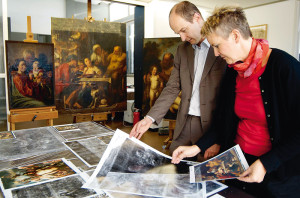 Die Vorbereitungszeit war intensiv. Dr. Justus Lange und Anne Harmssen begutachten im Gemälderestaurierungsatelier auf Schloß Wilhelmshöhe Röntgenaufnahmen der Jordaens-Gemälde. Im Hintergrund sind auf den Staffeleien Werke von Jacob Jordaens und seiner Werkstatt zu sehen: „Die heilige Familie“ (links), „Satyr beim Bauern“ (Mitte) und „Die Erziehung des Jupiter“ (rechts). Foto: Mario Zgoll