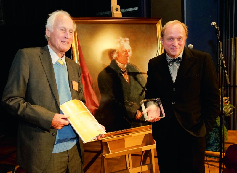 Preisstifter Eberhard Schöck und Preisträger Ulrich Tukur, dazwischen der grimmig dreinblickende Namensgeber des Preises in Öl. Foto: Mario Zgoll