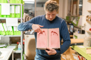 Markus Schott zeigt exemplarisch Fußabdrücke, an die die Fußbetten angepasst werden. Foto: www.memaha.de
