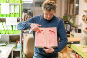 Markus Schott zeigt exemplarisch Fußabdrücke, an die die Fußbetten angepasst werden. Foto: www.memaha.de 