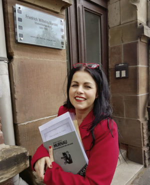 Kunstpädagogin Christel Schmieling-Burow vor dem Eingang zur Elfbuchenstraße 4, in der Friedrich Wilhelm Murnau von 1898 bis 1902 mit seiner Familie wohnte. In der Hand hält sie eine Monographie über den Stummfilmregisseur, die der spätere Jérôme-Redakteur Klaus Becker im Jahr 1981 für die Veranstaltung »Die Region trifft sich – die Region erinnert sich« verfasste. Foto: Jan Hendrik Neumann Kunstpädagogin Christel Schmieling-Burow vor dem Eingang zur Elfbuchenstraße 4, in der Friedrich Wilhelm Murnau von 1898 bis 1902 mit seiner Familie wohnte. In der Hand hält sie eine Monographie über den Stummfilmregisseur, die der spätere Jérôme-Redakteur Klaus Becker im Jahr 1981 für die Veranstaltung »Die Region trifft sich – die Region erinnert sich« verfasste. Foto: Jan Hendrik Neumann